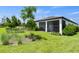 Lush backyard featuring a manicured lawn, mature trees, and a screened-in patio area at 14560 Eagle Branch Dr, Nokomis, FL 34275