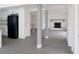 Open basement with gray flooring, white pillars and a fireplace creating a versatile space at 7314 Patio Row, Hudson, FL 34667