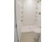 Bright bathroom featuring a walk-in shower with built-in shelves and a modern toilet at 7314 Patio Row, Hudson, FL 34667