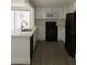 Modern kitchen featuring white cabinets, quartz countertops, and black appliances at 7314 Patio Row, Hudson, FL 34667