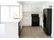 Bright kitchen features white cabinets, quartz counters, stainless sink and black appliances at 7314 Patio Row, Hudson, FL 34667