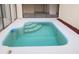 Kidney-shaped pool with steps, blue trim and coping, set in a bright, modern yard at 7314 Patio Row, Hudson, FL 34667
