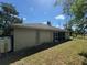 Back exterior view of house showcasing the covered patio and manicured lawn at 2305 De Vore St, North Port, FL 34291