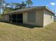 Exterior view of home showing covered patio, hurricane shutters and green lawn at 2305 De Vore St, North Port, FL 34291