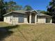Exterior elevation view of home displaying hurricane shutters and green front lawn at 2305 De Vore St, North Port, FL 34291