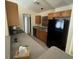 Functional kitchen featuring wood cabinets, laminate countertops, and black appliances at 2305 De Vore St, North Port, FL 34291