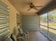 Covered patio featuring a ceiling fan, two chairs, and a screened opening to yard at 2305 De Vore St, North Port, FL 34291