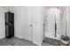 Bathroom showcasing white walls, gray wood-look floors, and a glass-enclosed shower with a gray mat at 5424 Companion Ln, Tampa, FL 33619