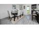 Dining room features a table with upholstered chairs and bench, floral wall art, and wood-look flooring at 5424 Companion Ln, Tampa, FL 33619