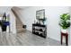 Welcoming foyer featuring stylish gray wood floors, staircase, black console table with decor and a mirror at 5424 Companion Ln, Tampa, FL 33619