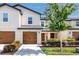 Charming two-story townhome featuring a well-manicured lawn and a welcoming front entrance and brown garage door at 5424 Companion Ln, Tampa, FL 33619