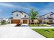 Street view of a two-story townhome showcases attached garages, green grass, and inviting landscaping at 5424 Companion Ln, Tampa, FL 33619