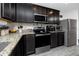 Modern kitchen features dark cabinetry, stainless steel appliances, granite countertops, and wood-look flooring at 5424 Companion Ln, Tampa, FL 33619
