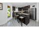 A modern kitchen features dark cabinetry, stainless steel appliances, an island, and wood-look flooring at 5424 Companion Ln, Tampa, FL 33619
