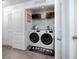 Bright laundry room with stacked front load washer and dryer and a 'Laundry Room Loads of Fun' mat at 5424 Companion Ln, Tampa, FL 33619
