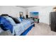 Bright main bedroom with a tv and ample space, featuring a bed with stylish blue and black accents at 5424 Companion Ln, Tampa, FL 33619