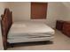 A minimalist bedroom featuring a simple bed and a dark wood dresser at 5905 Cleveland Dr, Punta Gorda, FL 33982