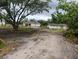 View of house with an attached two car garage and outbuilding surrounded by grassy areas and trees at 5905 Cleveland Dr, Punta Gorda, FL 33982