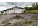 Side view of a house with an attached two car garage surrounded by debris at 5905 Cleveland Dr, Punta Gorda, FL 33982