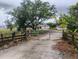 Gated driveway lined with a rustic wooden fence and mature trees leads to the property at 5905 Cleveland Dr, Punta Gorda, FL 33982