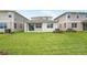 Wide shot of a grassy backyard and patio, flanked by neighboring houses at 6038 Jensen View Ave, Apollo Beach, FL 33572