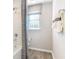 Bright bathroom with wood-style floors, white towels and a shower-tub with gray shower curtains at 6038 Jensen View Ave, Apollo Beach, FL 33572