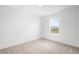 Well lit bedroom with a single window showing views of adjacent houses and a carpeted floor at 6038 Jensen View Ave, Apollo Beach, FL 33572