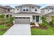 Charming gray two-story home with stone accents, a gray garage door, and well-manicured landscaping at 6038 Jensen View Ave, Apollo Beach, FL 33572