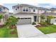 Beautiful two-story home featuring gray siding, stone accents, a gray garage door, and landscaping at 6038 Jensen View Ave, Apollo Beach, FL 33572
