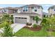 Stylish two-story home with gray siding, stone details, a gray garage door, and a landscaped front yard at 6038 Jensen View Ave, Apollo Beach, FL 33572