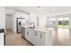 Bright, open kitchen with a center island, stainless steel appliances, and wood-look tile flooring at 6038 Jensen View Ave, Apollo Beach, FL 33572
