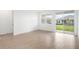 Open living room featuring wood-look flooring and large glass doors to the outdoor space at 6038 Jensen View Ave, Apollo Beach, FL 33572