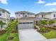 Charming two-story home features a two-car garage, well-manicured lawn, and lush landscaping at 6042 Jensen View Ave, Apollo Beach, FL 33572