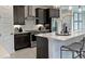 Modern kitchen with stainless steel appliances, quartz countertops, tile backsplash, dark cabinets and decorative lighting at 6042 Jensen View Ave, Apollo Beach, FL 33572