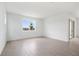 Minimalist living room features neutral walls, tiled floors, and a large window with an outside view at 6042 Jensen View Ave, Apollo Beach, FL 33572