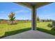 Inviting covered back patio with a view of the backyard and manicured lawn at 6046 Jensen View Ave, Apollo Beach, FL 33572