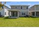 Spacious backyard view with covered patio, lawn, and well-maintained landscaping at 6046 Jensen View Ave, Apollo Beach, FL 33572