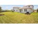 Lush backyard featuring green lawn and view of the home's exterior at 6058 Jensen View Ave, Apollo Beach, FL 33572