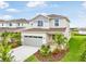 Exterior shot of a two-story home featuring a well-manicured lawn, colorful landscaping, and a two-car garage at 6058 Jensen View Ave, Apollo Beach, FL 33572
