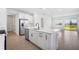 Bright kitchen featuring white cabinetry, stainless steel appliances, a kitchen island, and wood-look tile flooring at 6058 Jensen View Ave, Apollo Beach, FL 33572