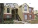 Two-story condo building featuring a brick and yellow exterior with a black stairway and large windows at 8728 Mallard Reserve Dr # 103, Tampa, FL 33614