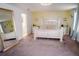 Bedroom featuring neutral carpet, decorative headboard, and access to the attached bathroom at 12236 Fairlawn Dr, Riverview, FL 33579