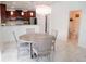 Elegant dining area featuring marble flooring, a modern chandelier, and an adjacent kitchen with stainless steel appliances at 12236 Fairlawn Dr, Riverview, FL 33579