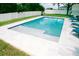 Sparkling in-ground pool surrounded by a white fence and lush green grass and lounge chairs at 12236 Fairlawn Dr, Riverview, FL 33579
