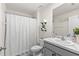 Bright bathroom featuring white cabinetry with marble countertop and a shower with white curtain at 16750 Sunburst Lake St, Wimauma, FL 33598