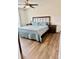 Bedroom with modern furniture, a large bed, wood floor and a ceiling fan at 16750 Sunburst Lake St, Wimauma, FL 33598