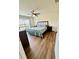 Cozy bedroom featuring wood floors, ceiling fan, queen bed, and natural light at 16750 Sunburst Lake St, Wimauma, FL 33598