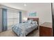 Bedroom with a queen bed and large window with natural light and blue accents at 16750 Sunburst Lake St, Wimauma, FL 33598