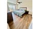 Bedroom with modern furniture, a large bed, wood floor and a ceiling fan at 16750 Sunburst Lake St, Wimauma, FL 33598