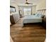 Comfortable bedroom with wood floors, ceiling fan, and dresser at 16750 Sunburst Lake St, Wimauma, FL 33598